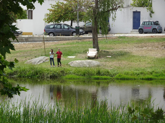 Children fishing in a pond. Also, a very strange car.