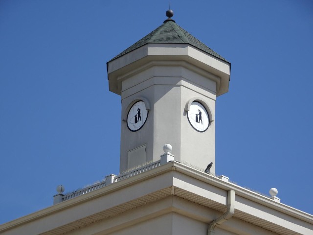 What looks like it should be a clock tower instead has pictures of a blacksmith within the outline o...