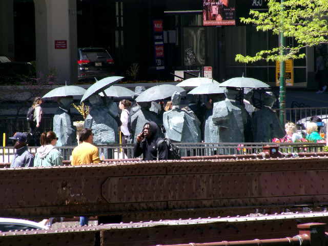 A statue of a group of people with umbrellas.